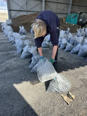 A team member sorting bagged material inside the sampling workspace.