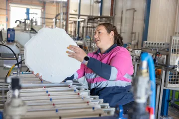 A team member handling a circular filter plate beside the pilot equipment.