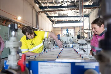 Two team members leaning over the filtration equipment during an inspection.