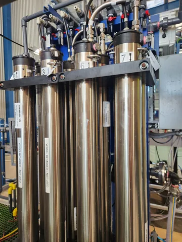 A close view of the tall stainless-steel treatment columns and connecting pipework.