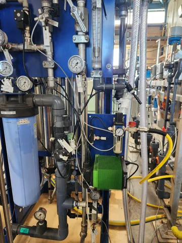 Blue treatment vessels surrounded by valves, pipework and monitoring instruments.